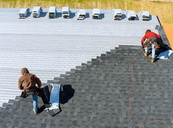 Roofers working on a low-slope roof installation in NYC